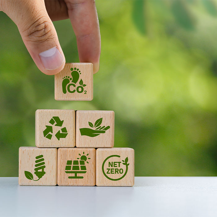 Petits cubes en bois disposés en pyramide, symboles sur l'environnement, bilan carbone et reconditionnement